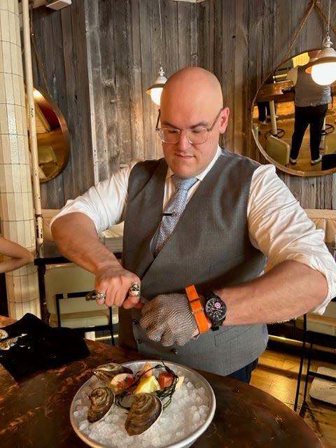 Jeremy Benson, general manager of New York's Crave Fishbar, demonstrates the proper oyster shucking technique, as well as the chain-mail glove worn for safety.