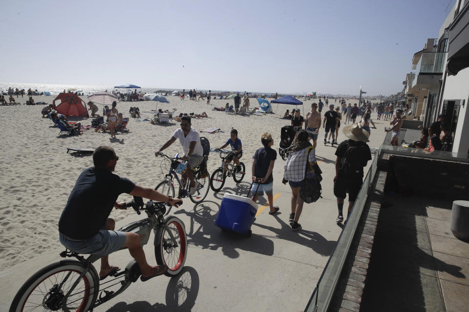 Visitors use a bike and walking path Sunday, May 24, 2020, in Newport Beach, Calif., during the coronavirus outbreak. (AP Photo/Marcio Jose Sanchez)