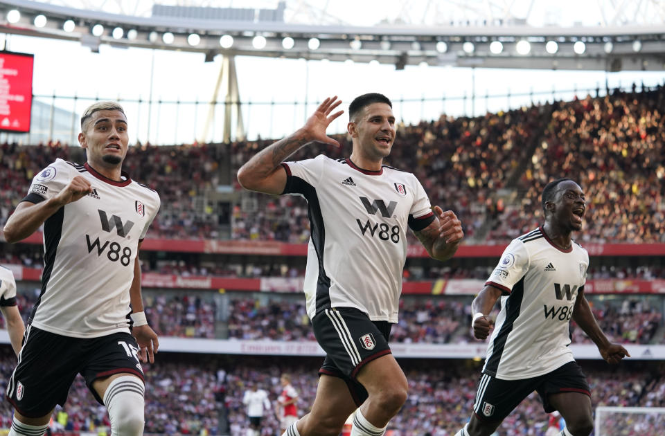 Fulham's Aleksandar Mitrovic, centre, celebrates after scoring his side's opening goal during the English Premier League soccer match between Arsenal and Fulham at the Emirates Stadium, London, England, Saturday, Aug. 27, 2022. (AP Photo/Alberto Pezzali)