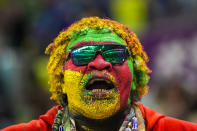 A Cameroon fan cheers up at the stand prior the World Cup group G soccer match between Cameroon and Brazil, at the Lusail Stadium in Lusail, Qatar, Friday, Dec. 2, 2022. (AP Photo/Andre Penner)