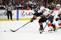 Washington Capitals left wing Alex Ovechkin (8) and Florida Panthers defenseman Radko Gudas (7) chase the puck during the first period of an NHL hockey game, Friday, Nov. 26, 2021, in Washington. (AP Photo/Nick Wass)