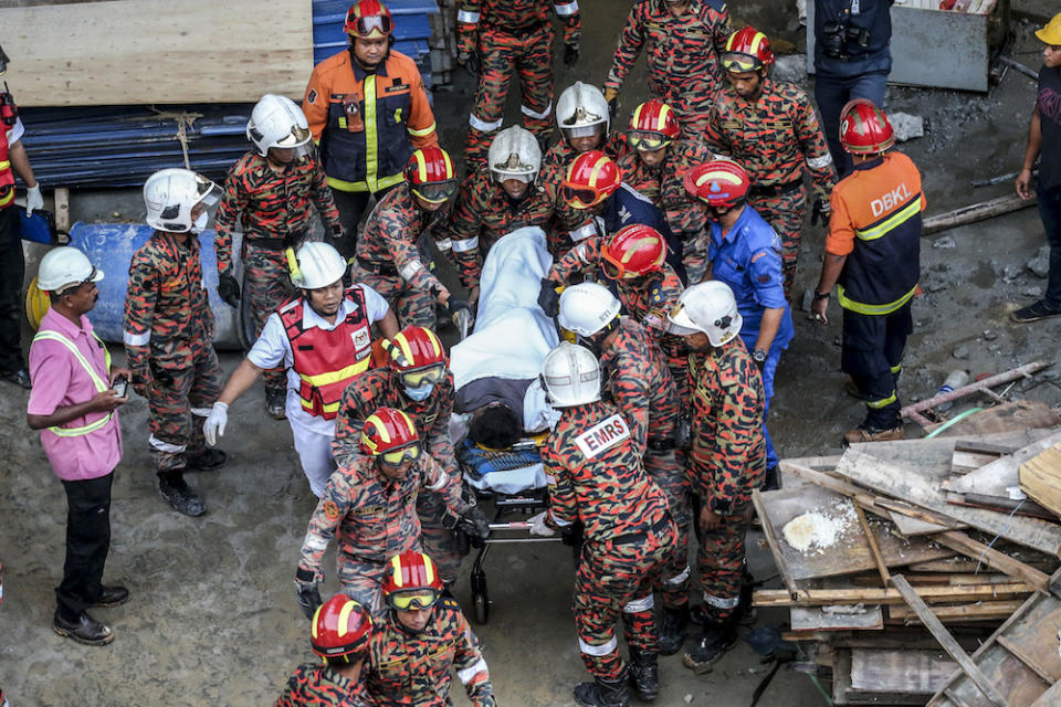 Fire and rescue personnel carry an injured man from the site of the Gombak Integrated Transport Terminal car park collapse in Kuala Lumpur May 23,2019. — Picture by Firdaus Latif