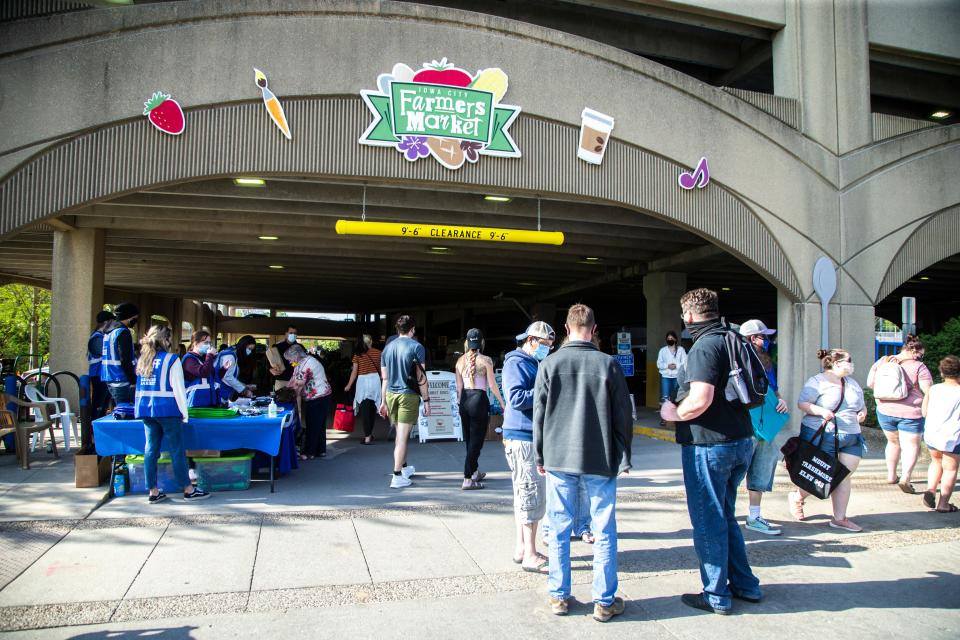 Community members browse shops during the first day of the Iowa City Farmers Market, Saturday, May 1, 2021, at the Chauncey Swan Parking Ramp in Iowa City, Iowa.