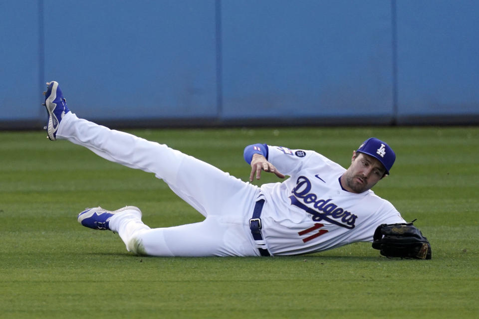 Los Angeles Dodgers left fielder AJ Pollock makes a sliding catch on a ball hit by Washington Nationals' Victor Robles during the first inning of a baseball game Saturday, April 10, 2021, in Los Angeles. (AP Photo/Mark J. Terrill)