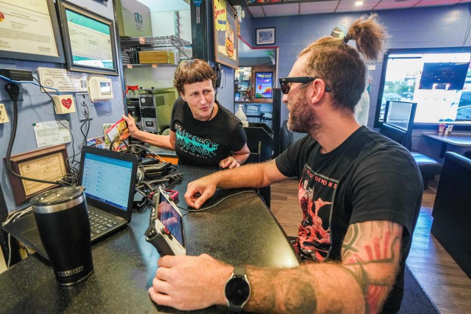 Much of Magnolia Cafe's success can be credited to its longtime employees, like Amanda Blanks (left), seen her checking in on regular customer Nicholas Hargrove.