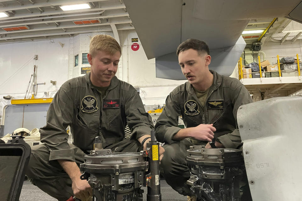 Attack helicopter pilot Marine Capt. Sam Peters, and ordnance technician Sgt. Michael Cole inspect a gun part on the USS Bataan in the Aegean Sea, Greece, Friday, Jan. 19, 2024. The Bataan, an amphibious assault ship, is leading a U.S. Navy task force in the eastern Mediterranean as the United States maintains an increased level of military deployment in the Middle East. (AP Photo/Derek Gatopoulos)