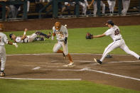 Texas outfielder Eric Kennedy (30) runs home on a wild pitch by Virginia pitcher Mike Vasil (48) during a baseball game in the College World Series Thursday, June 24, 2021, at TD Ameritrade Park in Omaha, Neb. (AP Photo/John Peterson)