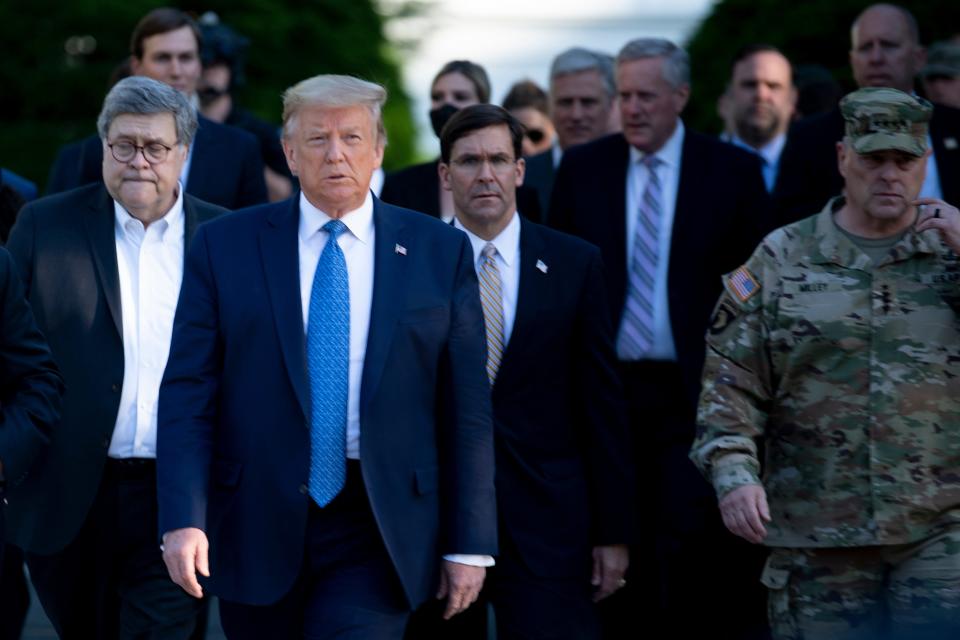 President Donald Trump walks with Attorney General William Barr, left, Secretary of Defense Mark Esper and others from the White House to visit St. John's Church after the area was cleared of people protesting the death of George Floyd in Washington, June 1, 2020.