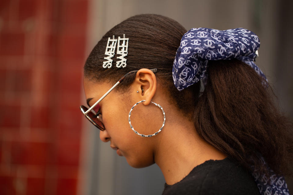 LONDON, ENGLAND - FEBRUARY 19: A guest is seen on the street during London Fashion Week February 2019 wearing navy Chanel hair bow with two 'Sweet' barrettes on February 19, 2019 in London, England. (Photo by Matthew Sperzel/Getty Images)