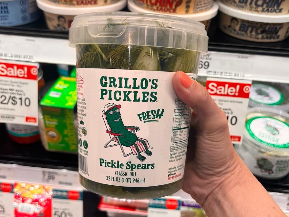 hand holding up a tub of grillo pickels at a target