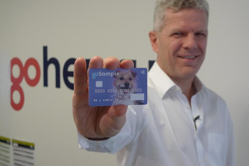 In this Oct. 17, 2018 photo, Alex Zivoder, CEO of Gohenry, a digital banking startup aimed at children, holds up a sample of the prepaid debit cards that the app comes with, in London. A wave of digital pocket money apps that come with prepaid cards are new tools for financial education as money increasingly goes digital, in a shift that’s raising uncertainty about how cashless transactions affect youngsters’ view of money. (AP Photo/Kelvin Chan)