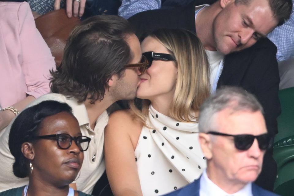 Ms Robbie shared a kiss with her husband in the Wimbledon crowd (WireImage)