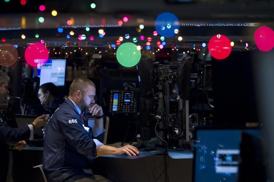 Trader Kevin Lodewick works on the floor of the New York Stock Exchange, which has been decorated with Christmas lights, in New York December 22, 2014.            REUTERS/Carlo Allegri      (UNITED STATES - Tags: BUSINESS)