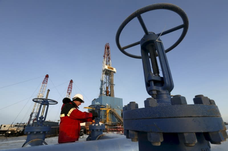 A worker checks a valve of an oil pipe at the Lukoil company owned Imilorskoye oil field outside the West Siberian city of Kogalym, Russia, in this January 25, 2016 file photo. REUTERS/Sergei Karpukhin/File Photo