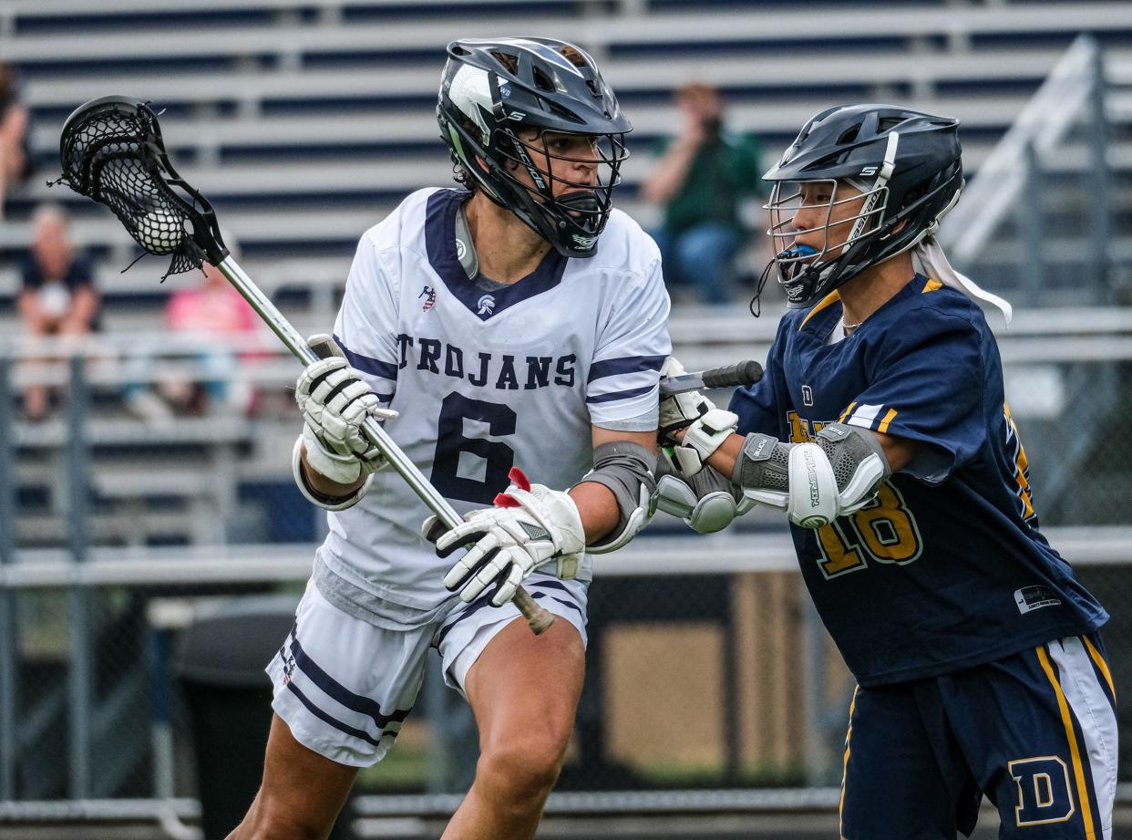 East Lansing senior Marcus Haynie (6) looks to score as Johna Boillat (18) from DeWitt tries to stop him in regional playoff action Friday, May 20, 2022. East Lansing won handily 19-8.