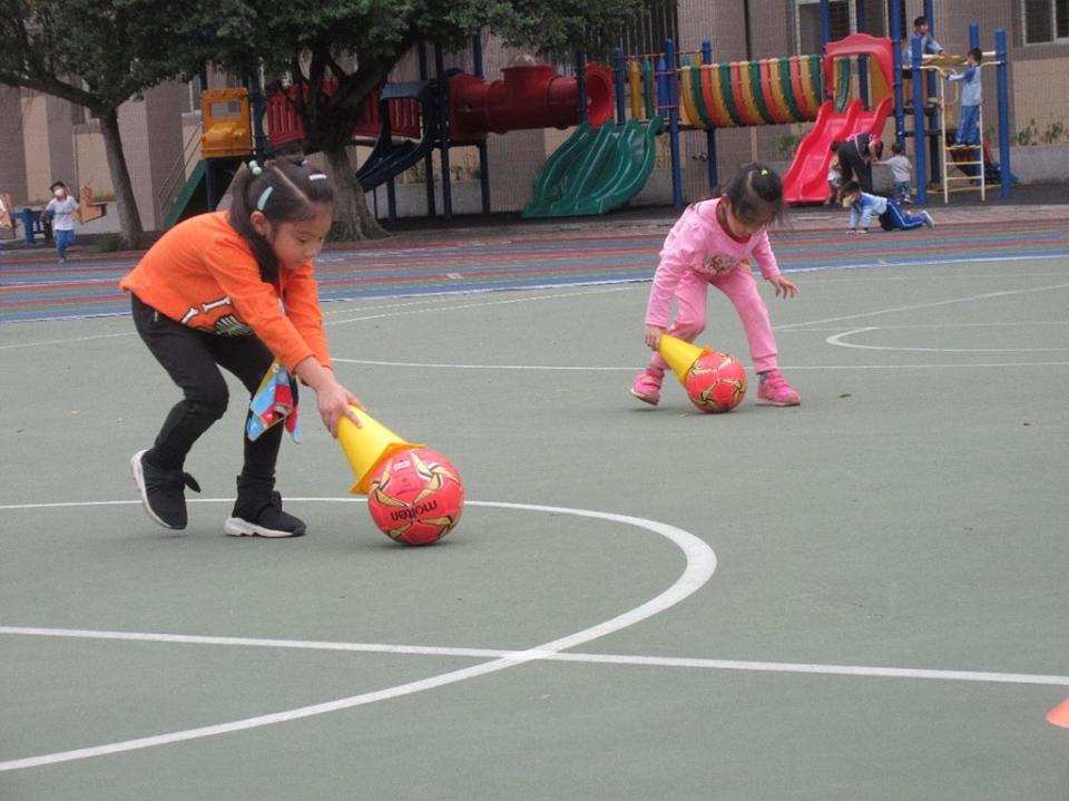 臺北市大安區大安國小附幼引導幼兒熟悉操控足球的技巧。