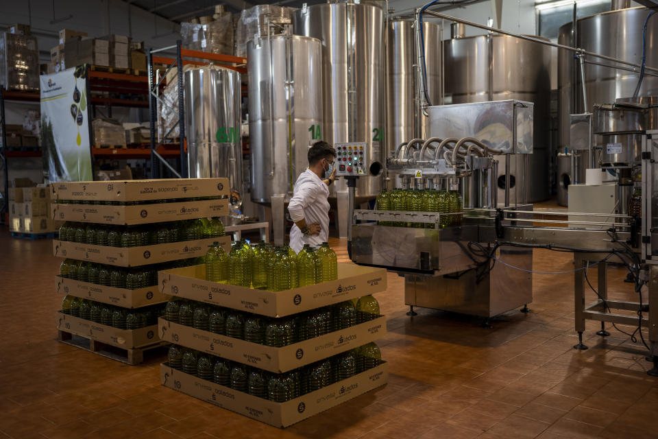 A worker supervises the olive oil bottling at the "La Betica Aceitera" olive mill in the southern town of Quesada, a rural community in the heartland of Spain's olive country, Thursday, Oct. 27, 2022. Spain, the world’s leading olive producer, has seen its harvest this year fall victim to the global weather shifts fueled by climate change. An extremely hot and dry summer that has shrunk reservoirs and sparked forest fires is now threatening the heartiest of its staple crops. (AP Photo/Bernat Armangue)