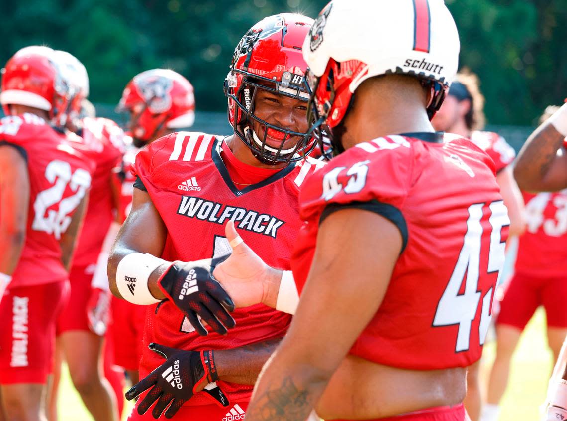 N.C. State’s Isaiah Moore (1) smile as he greets Davin Vann (45) during N.C. State football’s first practice of fall camp in Raleigh, N.C., Wednesday, August 3, 2022.