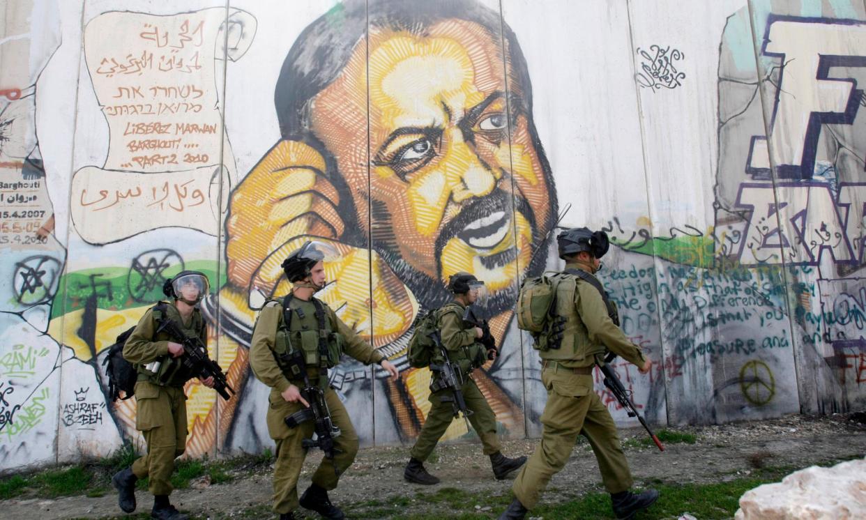 <span>Israeli soldiers patrol in the West Bank city of Ramallah with a mural showing Marwan Barghouti.</span><span>Photograph: Nasser Shiyoukhi/AP</span>