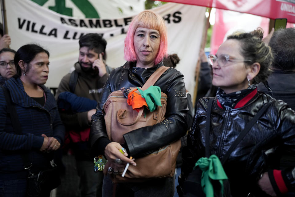 State workers Flavia, center, and Lia Pesaresi, right, protest the policies of President Javier Milei outside Congress, including the layoffs of some of their colleagues in Buenos Aires, Argentina, Friday, April 12, 2024. Milei's government has cut 15,000 state jobs over the past three months amid austerity measures. (AP Photo/Natacha Pisarenko)