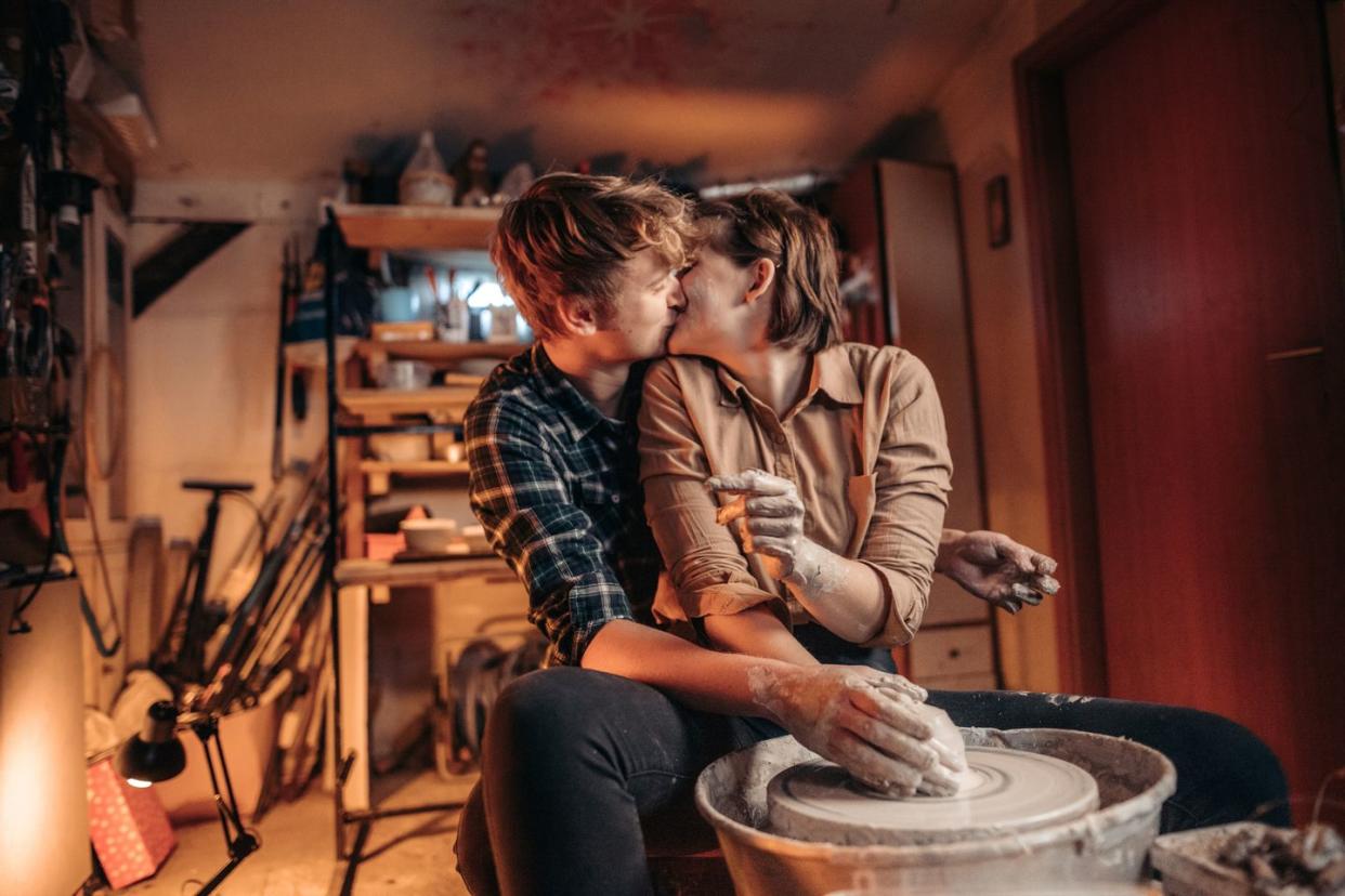 couple kissing and working in pottery