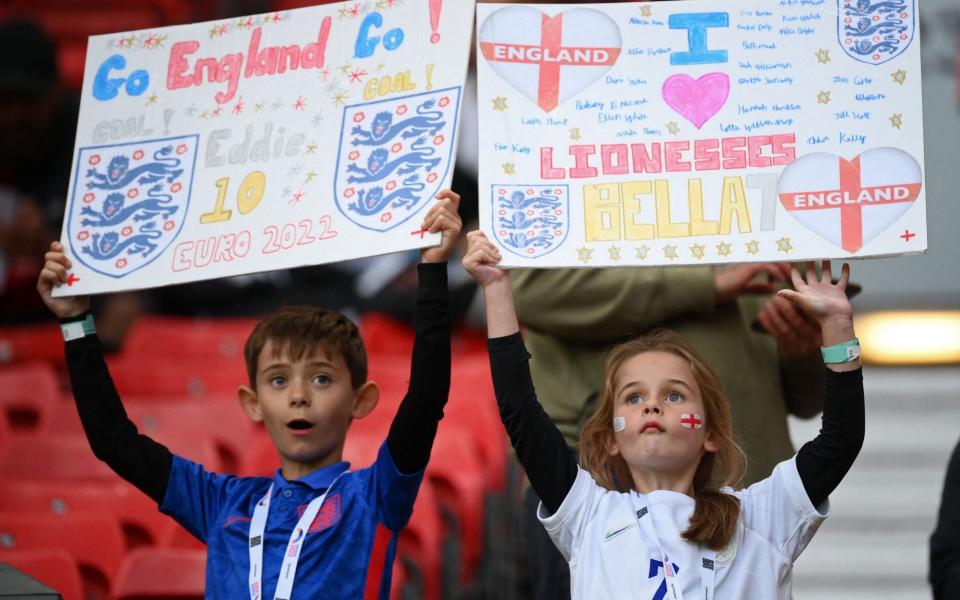 Young England fans hold up placards inside the stadium ahead of the UEFA Women's Euro 2022 Group A football match between England and Austria at Old Trafford in Manchester, north-west England on July 6, 2022 - Franck Fife/AFP