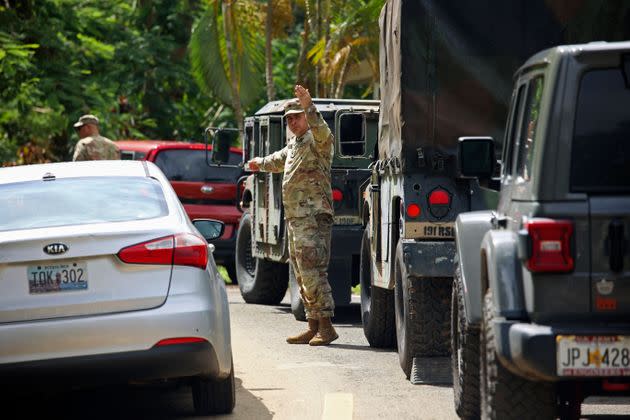 The National Guard directs traffic on a road affected by Hurricane Fiona in Cayey, Puerto Rico, on Tuesday. (Photo: Stephanie Rojas via Associated Press)