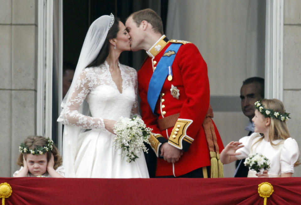 Britain's Prince William and his wife Catherine, Duchess of Cambridge, kiss as they stand next to bridesmaids Grace van Cutsem (L) and Margarita Armstrong-Jones (R) on the balcony at Buckingham Palace with other members of the Royal Family, after their wedding in Westminster Abbey, in central London April 29, 2011. Darren Staples / Reuters