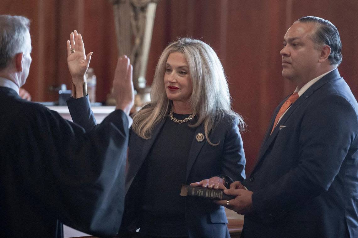 Angela Bisig, as her husband, Arnold Rivera, holds a Bible, is sworn in as a Kentucky Supreme Court justice by Chief Justice Laurance VanMeter during a ceremony in the Kentucky Supreme Court Courtroom in the state Capitol in Frankfort, Ky., on Tuesday, Jan. 10, 2023. Bisig was elected in November as the justice for the 4th Supreme Court District.