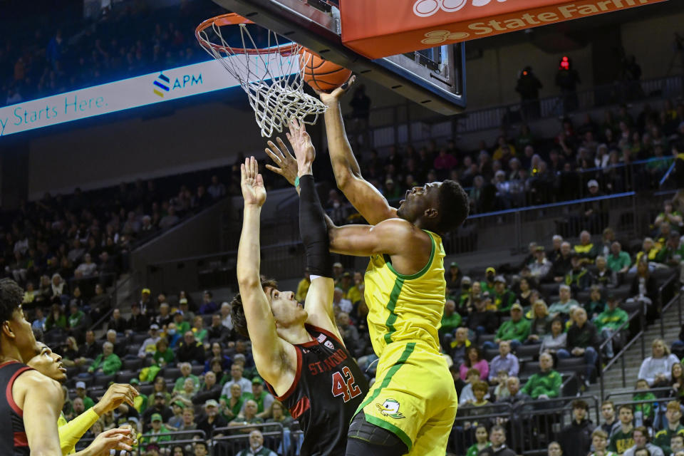 Oregon center N'Faly Dante (1) tries to lay in the ball as Stanford forward Maxime Raynaud (42) guards against him during the first half of an NCAA college basketball game Saturday, March 4, 2023, in Eugene, Ore. (AP Photo/Andy Nelson)