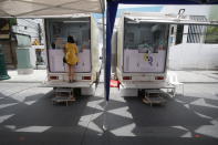 A woman waits for a COVID-19 swab test in front of one of the mobile testing units in Khaosan Road in Bangkok, Thailand Wednesday, April 14, 2021. Thailand recorded more than 1,000 COVID-19 infections on Wednesday, setting a daily record and adding pressure on the government to do more to control the country's spiking transmission rates. (AP Photo/Somchai Chanjirakitti)