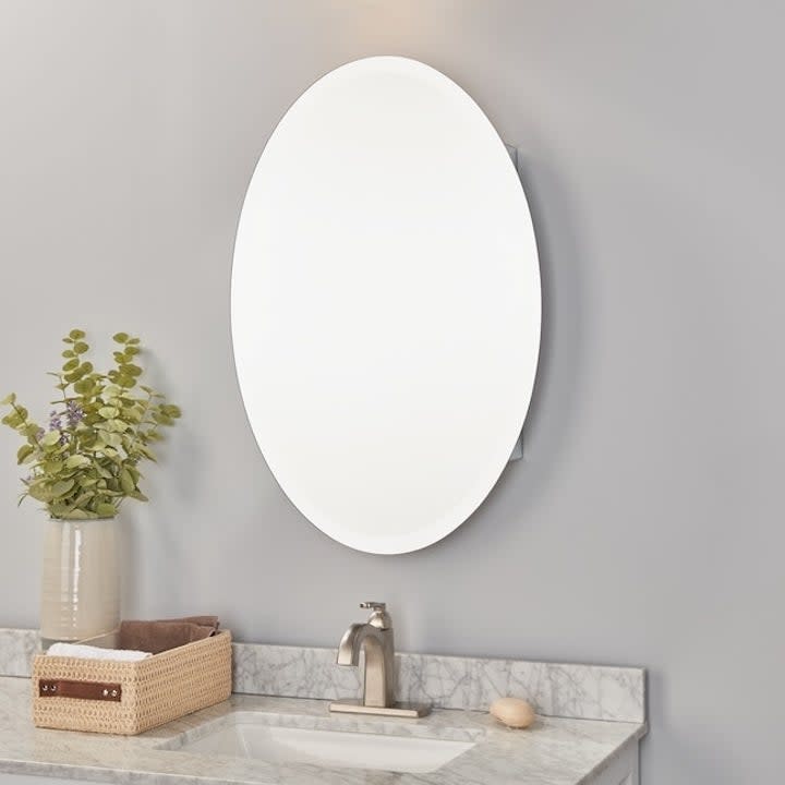 an oval vanity mirror in a bathroom