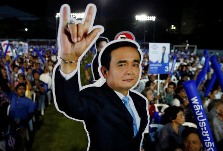 A supporter of Palang Pracharath Party holds a sign depicting Thailand's Prime Minister Prayut Chan-o-cha during the last party campaign rally outside a stadium in central Bangkok, Thailand, March 22, 2019. REUTERS/Soe Zeya Tun NO RESALES. NO ARCHIVES