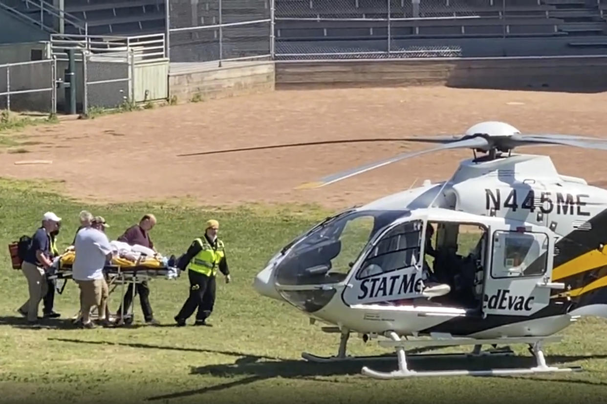 In this still image from video, author Salman Rushdie is taken on a stretcher to a helicopter for transport to a hospital after he was attacked during a lecture at the Chautauqua Institution in Chautauqua, N.Y., Friday, Aug. 12, 2022. (AP Photo)