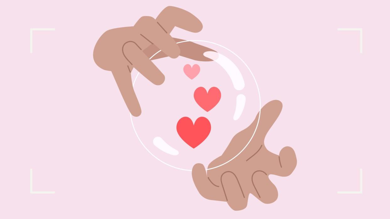  Image of hands around a crystal ball with love hearts in it  