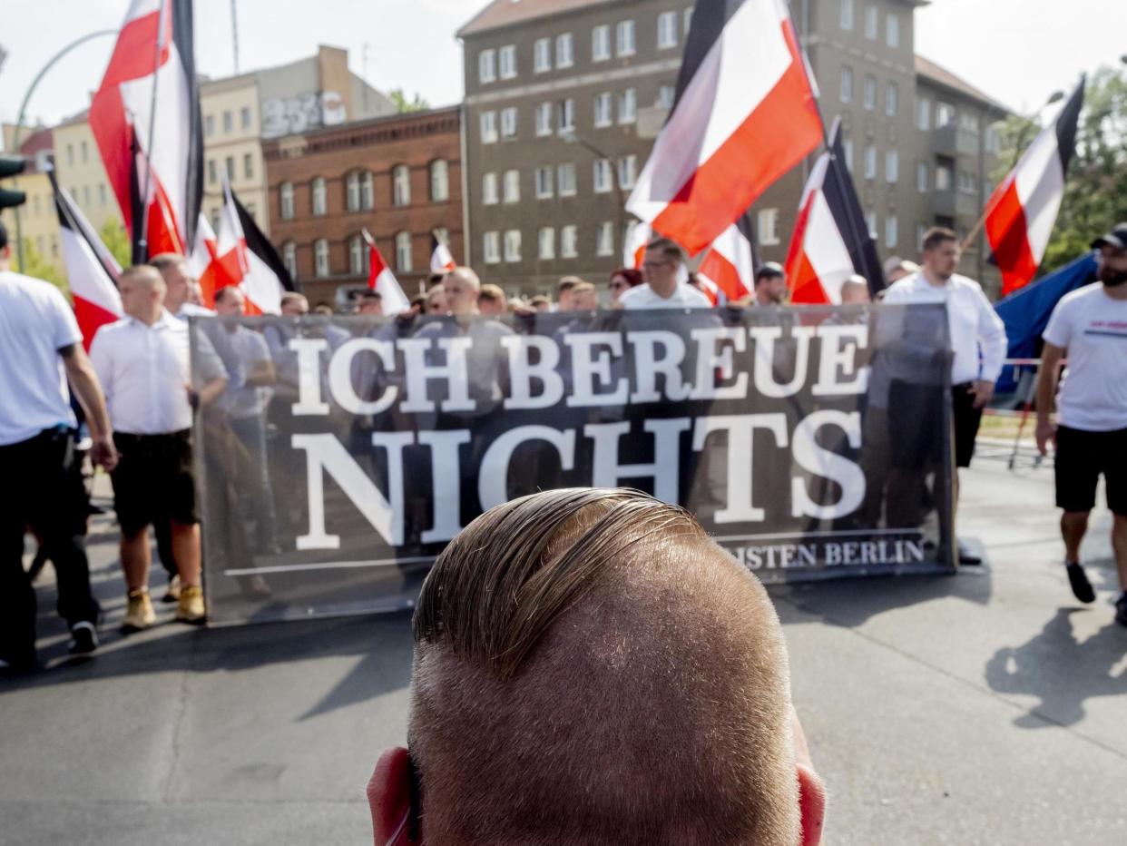 Marchers carry a banner reading 'I don't regret anything', marking the anniversary of the death of Rudolf Hess: AP