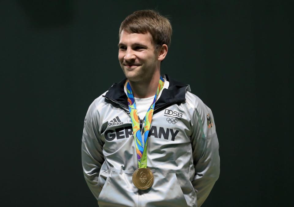 <p>Gold medalist Henri Junghaenel of Germany celebrates on the podium after winning the 50m rifle prone position event on Day 7 of the Rio 2016 Olympic Games at Olympic Shooting Centre on August 12, 2016 in Rio de Janeiro, Brazil. (Getty) </p>