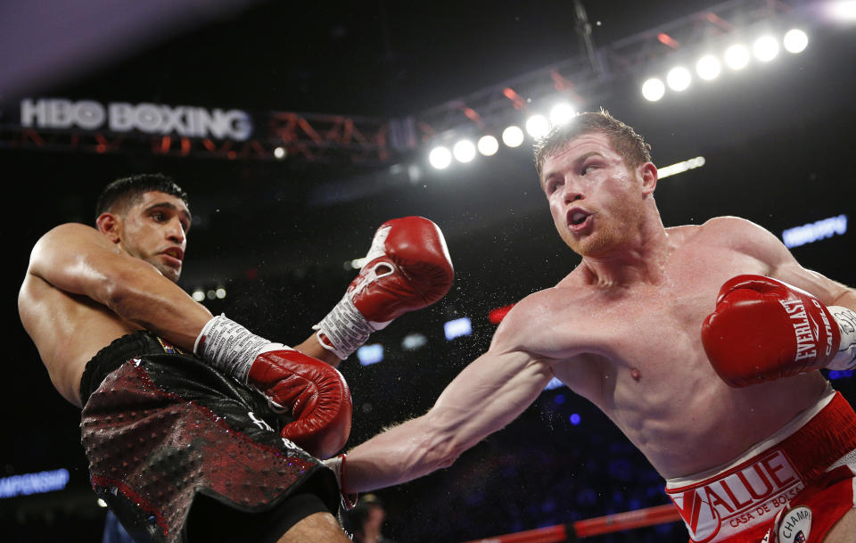 Canelo Alvarez, right, hits Amir Khan during their WBC middleweight title fight Saturday, May 7, 2016, in Las Vegas. (AP Photo/John Locher)