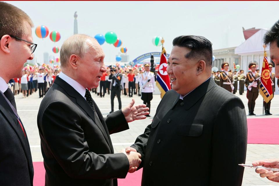 Kim Jong Un and Vladimir Putin shake hands at a welcoming ceremony for the Russian leader.