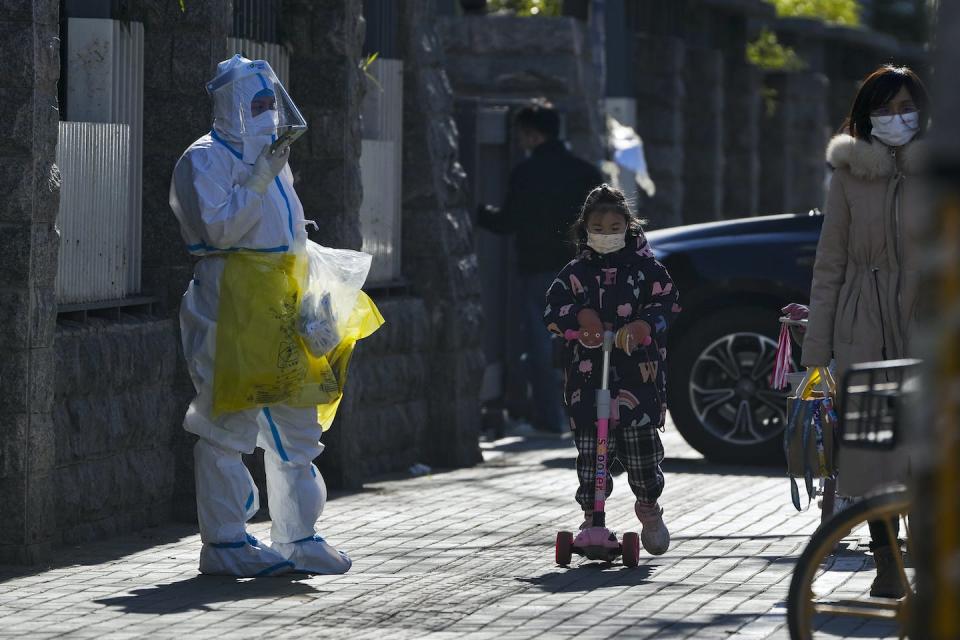 A worker in protective suit on his way to collect COVID samples from the lockdown residents in Beijing, on Dec. 1, 2022. (AP Photo/Andy Wong)