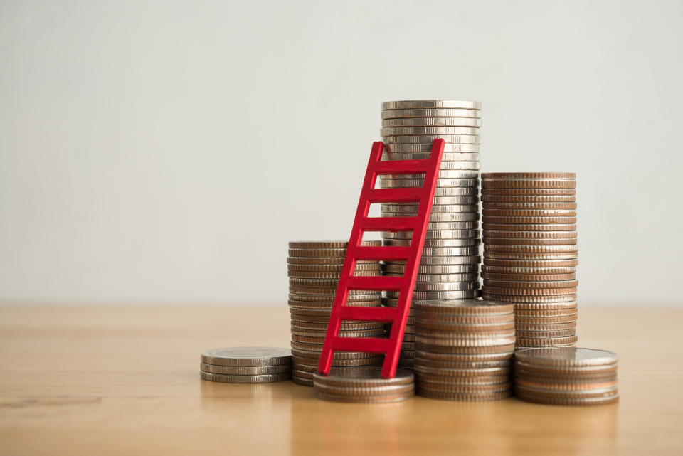 Red ladder and stack coin on wooden table with white wall background copy space. Money management planning, business strategy for growth profit step by step. Business, financial and investment concept