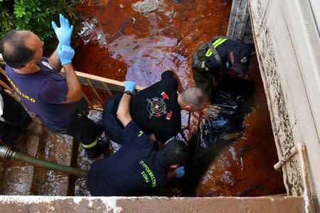 Rescue workers carry the body bag of a drowned woman away from her flooded house in Kalamata, Greece September 7, 2016. Eurokinissi/Dimitris Plemmenos via REUTERS