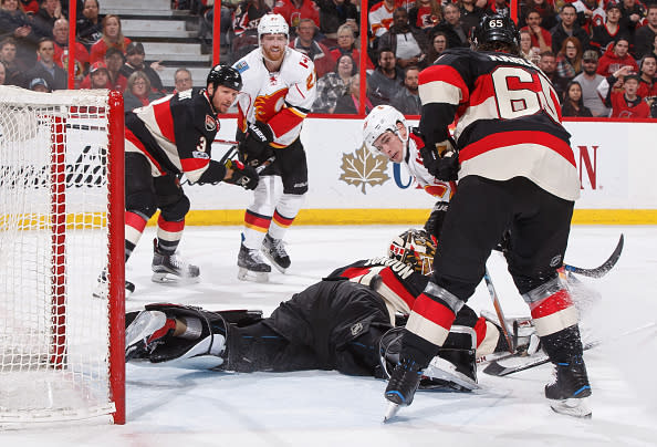 OTTAWA, ON - JANUARY 26: Sean Monahan #23 of the Calgary Flames flips the puck from between his legs over Mike Condon #1 of the Ottawa Senators for his second period goal as Marc Methot #3, Erik Karlsson #65 of the Ottawa Senators and Dougie Hamilton #27 of the Calgary Flames look on at Canadian Tire Centre on January 26, 2017 in Ottawa, Ontario, Canada. (Photo by Andre Ringuette/NHLI via Getty Images)