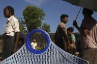 People walk between stalls at a market in Maungdaw town in northern Rakhine State November 11, 2014. REUTERS/Minzayar