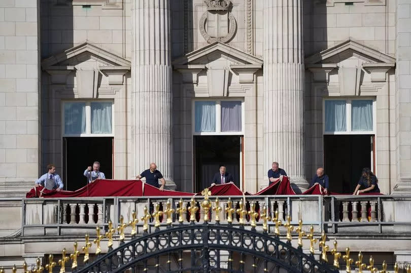 Royal household staff prepare the balcony at Buckingham Palace, London, ahead of members of the royal family appearing following the Trooping the Colour ceremony -Credit:PA