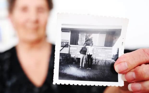 Ryczak holds a photograph of when she, pictured left, and Wallace first met in 1967, 17 years after their friendship started. 