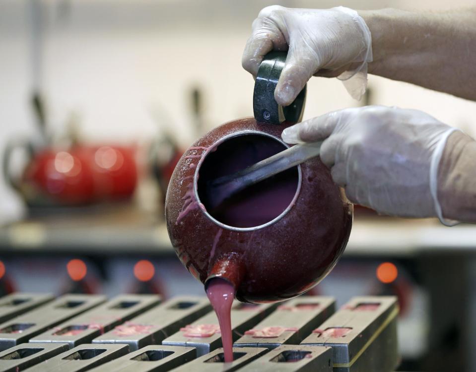 In this Dec. 6, 2012, photo, Mike Fitzgerald pours hot peppermint mixture into a mold while making peppermint pigs at his Saratoga Sweets store in Halfmoon, N.Y. A holiday tradition in upstate New York has a peppermint twist: pig-shaped hard candies are sold with little metal hammers to be smashed at Christmas. (AP Photo/Mike Groll)