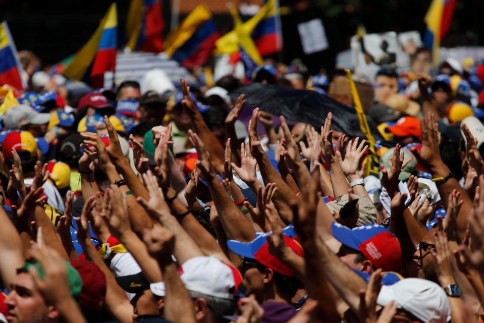 Supporters hold out their hands to greet Carlos Vecchio, the national political coordinator of the Popular Will party, an anti-government group formed by jailed opposition leader Leopoldo Lopez before his arrest, during an anti-government protest in Caracas, Venezuela, Saturday, March 22, 2014. Vecchio addressed the crowd in defiance of an arrest order. Two more people were reported dead in Venezuela as a result of anti-government protests even as supporters and opponents of President Nicolas Maduro took to the streets on Saturday in new shows of force. (AP Photo/Fernando Llano)