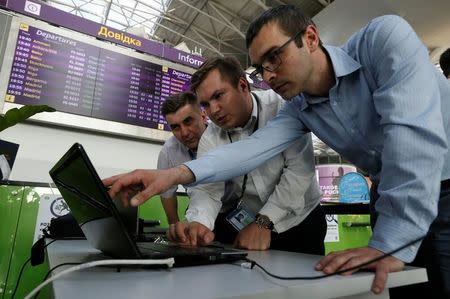 Technicians work on a flight timetable for the airport's site at the capital's main airport, Boryspil, outside Kiev, Ukraine, June 27, 2017. REUTERS/Valentyn Ogirenko