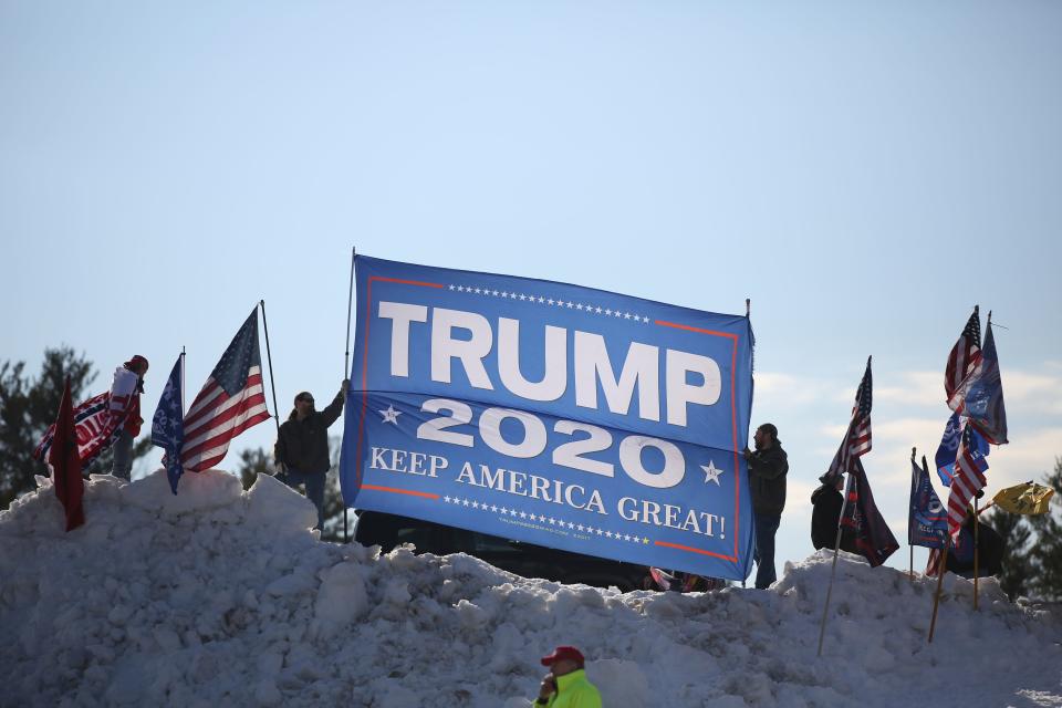 People took to a snowbank in the parking lot of Salem High School to show support for former President Donald Trump before he speaks during the New Hampshire Republican State Committee 2023 annual meeting, Saturday, Jan. 28, 2023, in Salem, N.H. (AP Photo/Reba Saldanha) ORG XMIT: NHRS101
